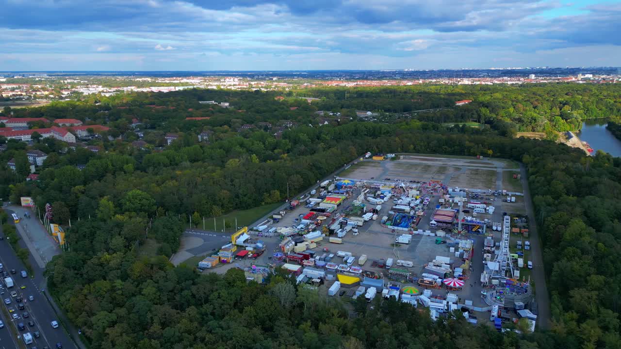 Berlin funfair showing a Ferris wheel, amusement rides, and various stalls from an aerial perspective. Perfect aerial view flight circle drone footage