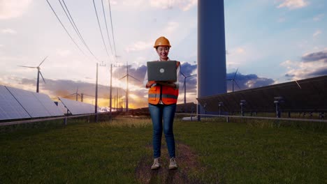 full body of asian female engineer with safety helmet working on a laptop with solar panel and wind turbines