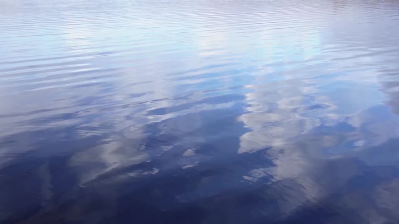 Clouds reflected in water surface slow motion