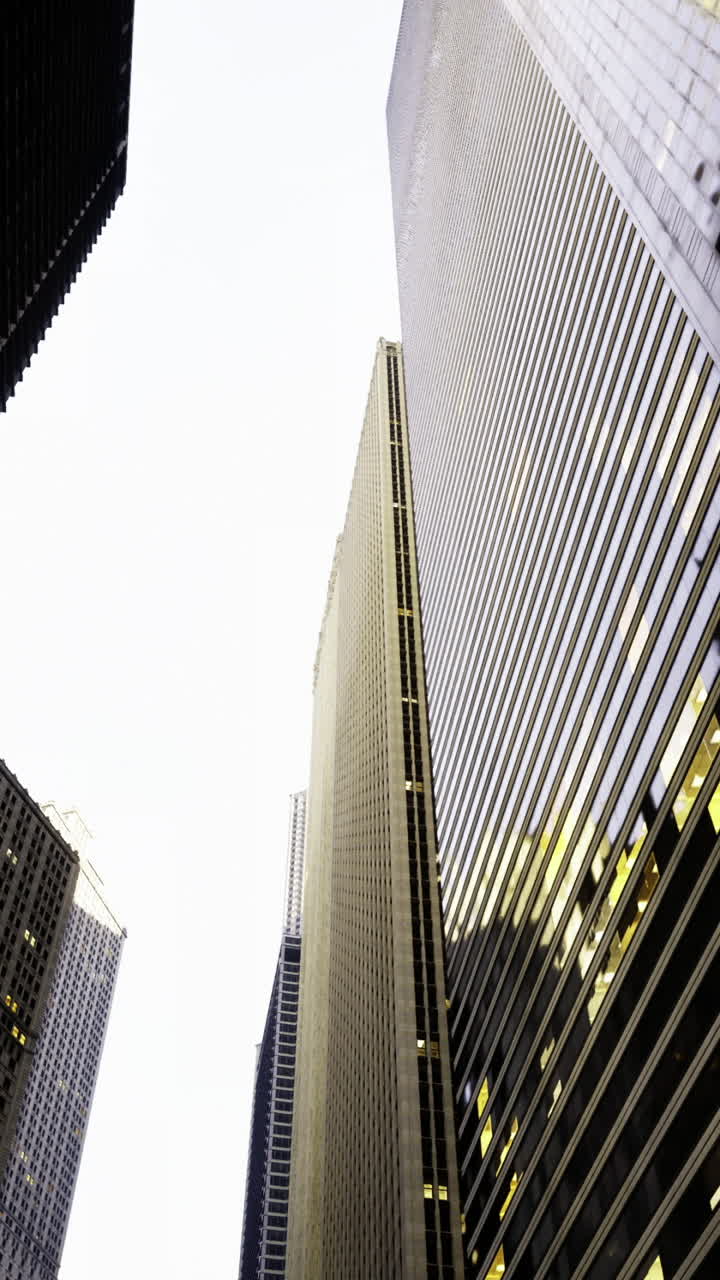 Urban skyline viewed from below with tall buildings and glowing windows