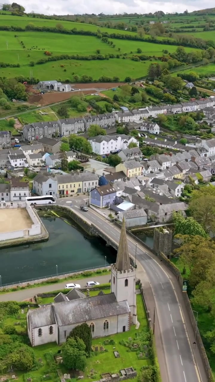 Video aereo in formato verticale per social media del villaggio di Glenarm, sulla Causeway Coastal Route nella Contea di Antrim, Irlanda del Nord nel Regno Unito in una giornata di sole. Prodotto in 3840x2160 e con colore Rec709.
