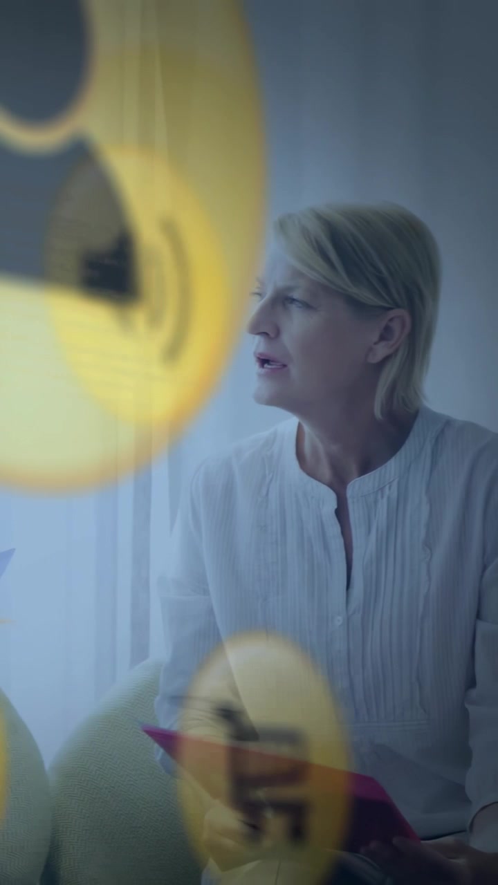 Woman lifting head man reading blue doc on couch sliding icons obscuring faces revealing sales data