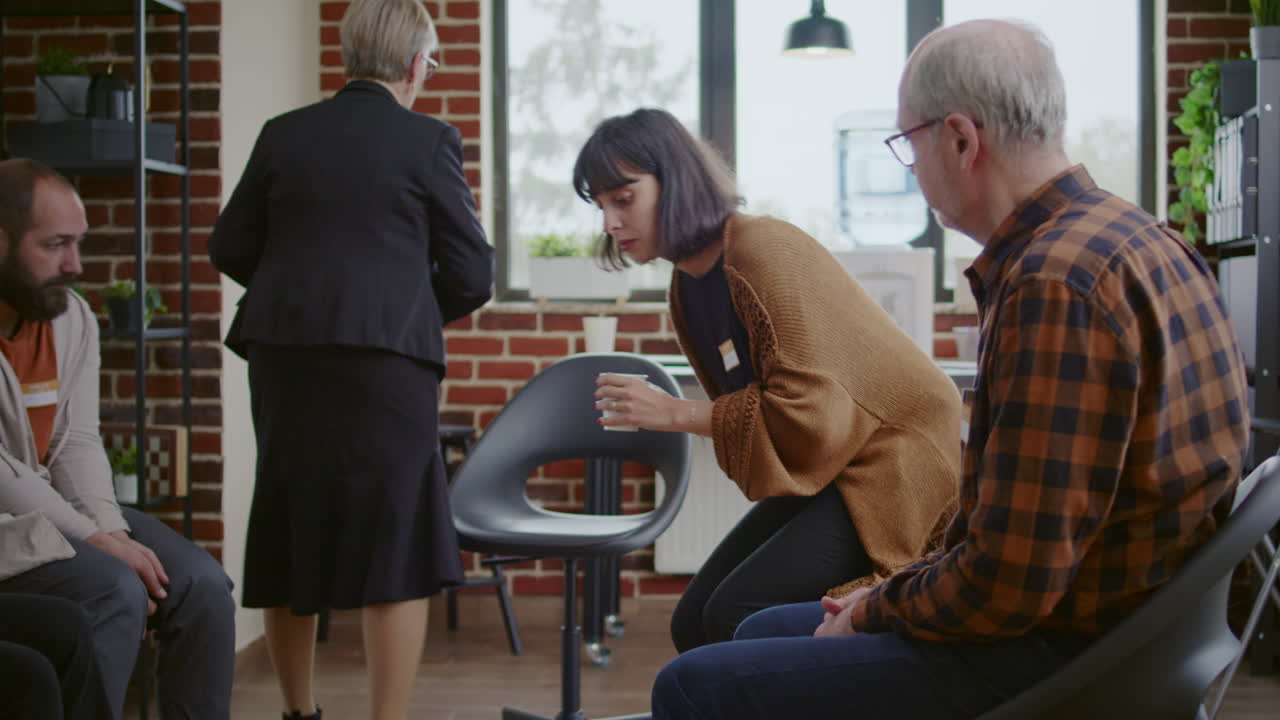 Multi ethnic people with alcohol addiction arriving at aa group meeting with therapist