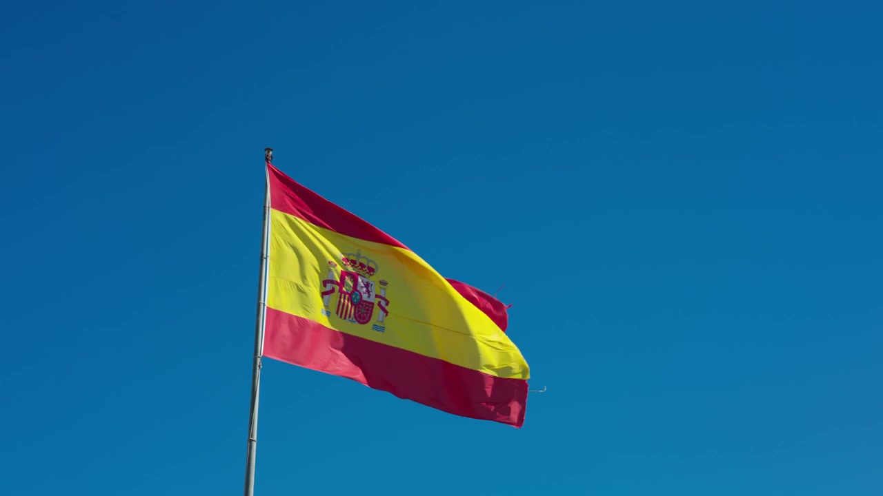 La bandiera della Spagna che sventola davanti a un cielo azzurro limpido.