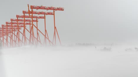 Low-Angle-Shot-Von-Flughafenlichtern,-Die-Von-Einem-Schweren-Schneesturm-Und-Starken-Winden-Inmitten-Einer-Weißen,-Schneebedeckten-Weite-In-Schweden-Bestraft-Werden