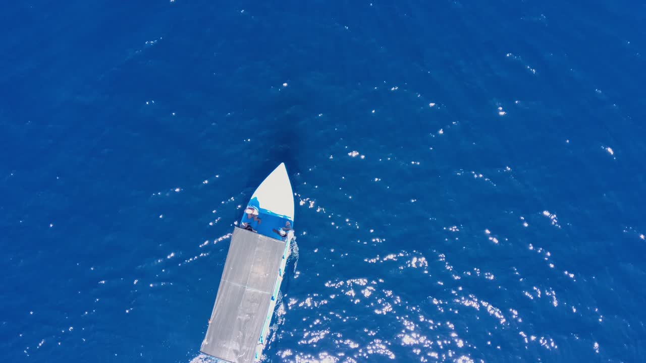 toma aérea superior de un barco turístico en el mar en una pequeña isla tropical con agua azul