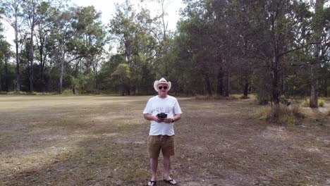 drone reversing away from man in a bushland setting