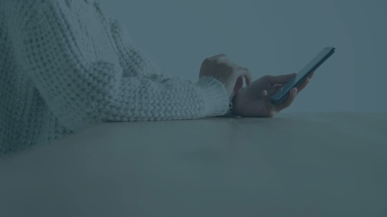 Woman raising phone at table, tapping and swiping while finance charts overlaying grid, updating %