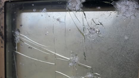 the scars of combat seen from inside an m2 bradley. this pov shot looks through a damaged ballistic shield as the vehicle operates near the frontline in ukraine