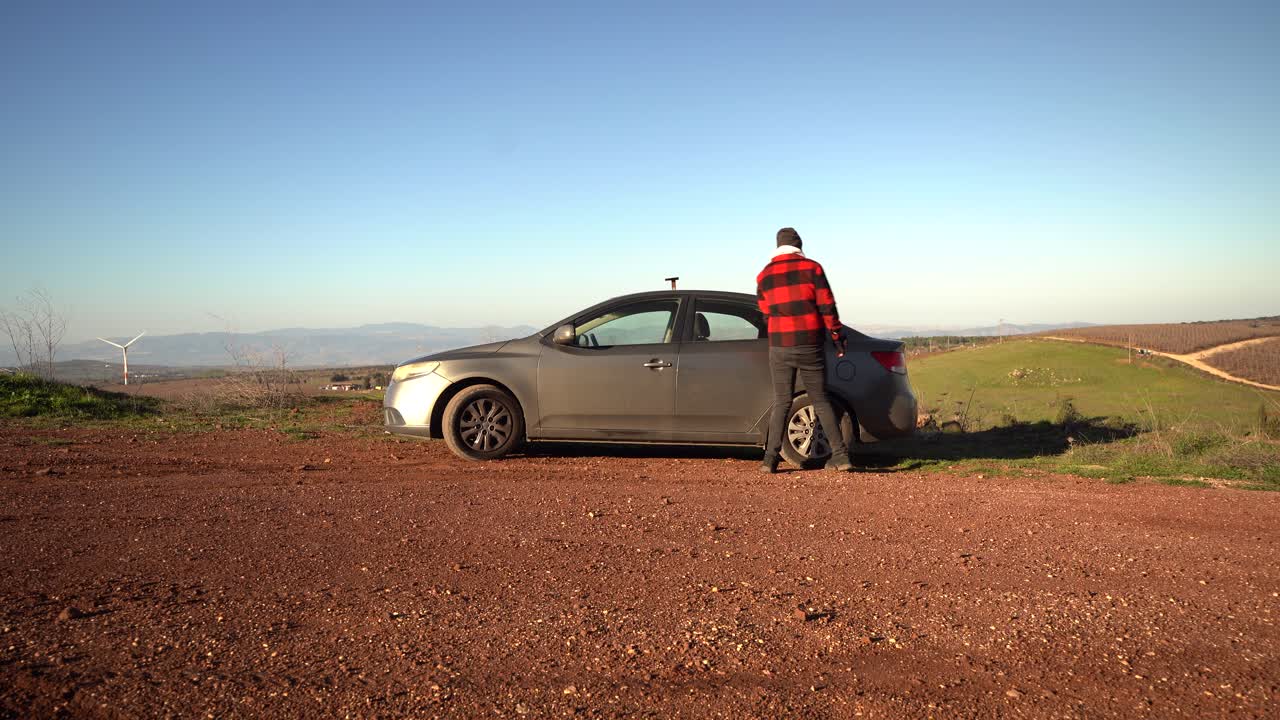 수염 난 백인 남자 4 도어 회색 차를 종료하고 배낭, 이스라엘을 잡아
