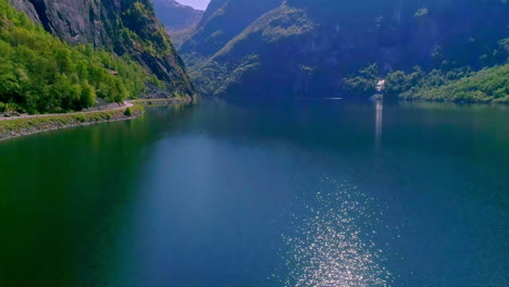 Flying-over-beautiful-landscape-view-of-mountains-and-lake-with-shimmering-water