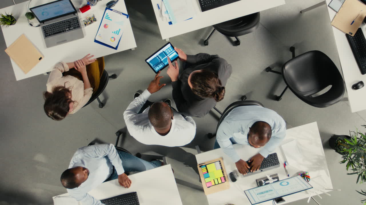 Lodret video. Top-down-perspektiv, zoom ud af et arbejds-hold i en multinational virksomhed