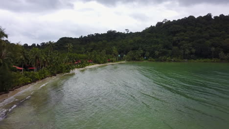 tropical beach view in ko kut, calm sea, lush greenery, peaceful mood