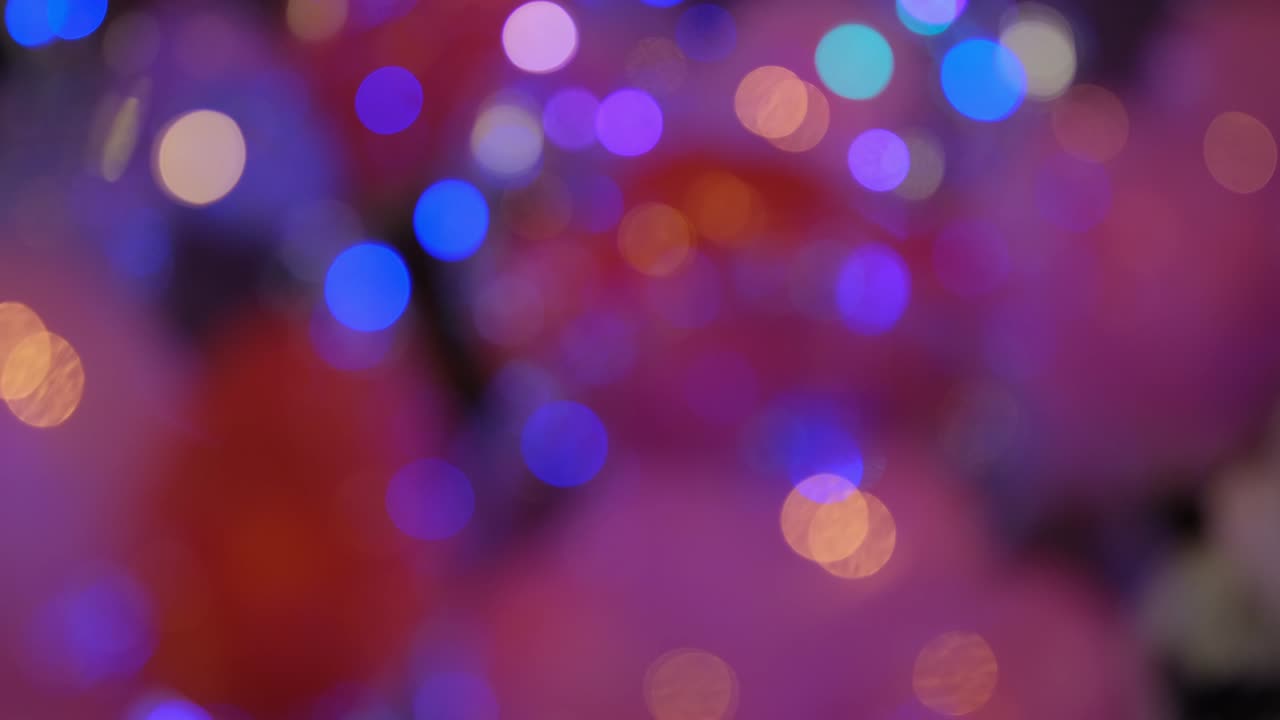 Shimmering abstract colored circles defocused christmas lights video. Blurred fairy lights. Out of focus holiday background christmas tree. Light bokeh from Xmas tree.