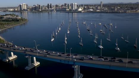 aerial view of coronado bridge with sailboats on san diego bay and the city skyline