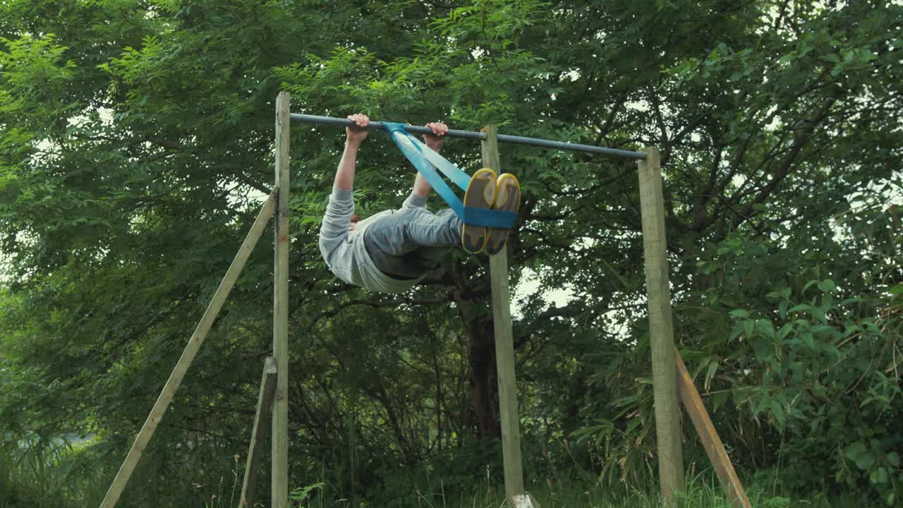 hombre joven en forma realizando ejercicio de palanca frontal usando banda de resistencia gimnasio en casa entrenamiento al aire libre