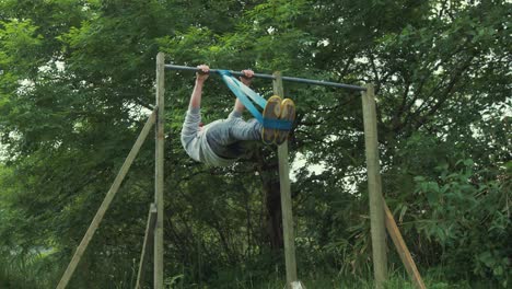 Fit-young-male-performing-front-lever-exercise-using-resistance-band-home-gym-outdoor-workout