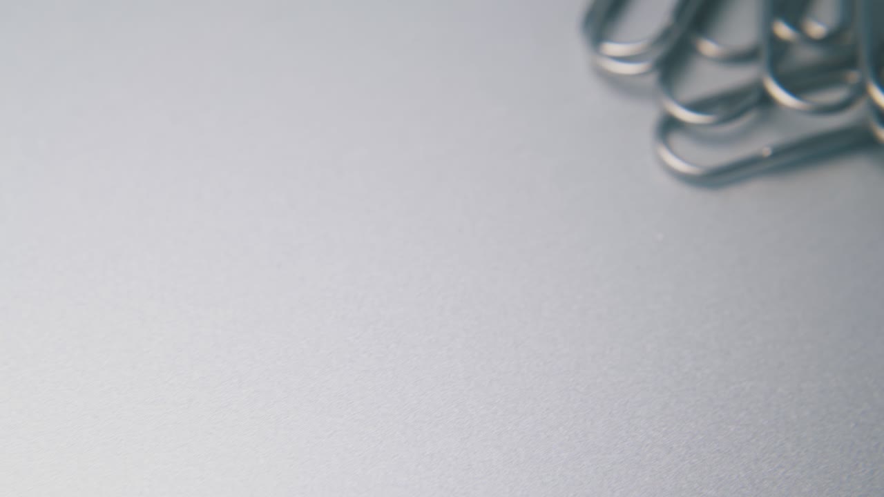 회색 표면 에 있는 학교 와 사무실 의 종이 클립 에 대한 움직임