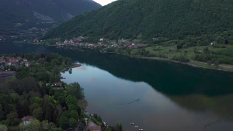 Drone-flying-over-Lake-Endine-with-the-mountains-in-the-background,Lombardy,Italy