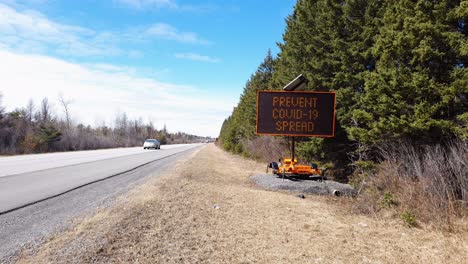 señal de construcción en la carretera que advierte sobre la propagación del coronavirus covid-19