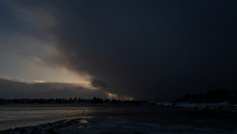 fast moving storm clouds time lapse in winter turning day into night. sunlight through clouds