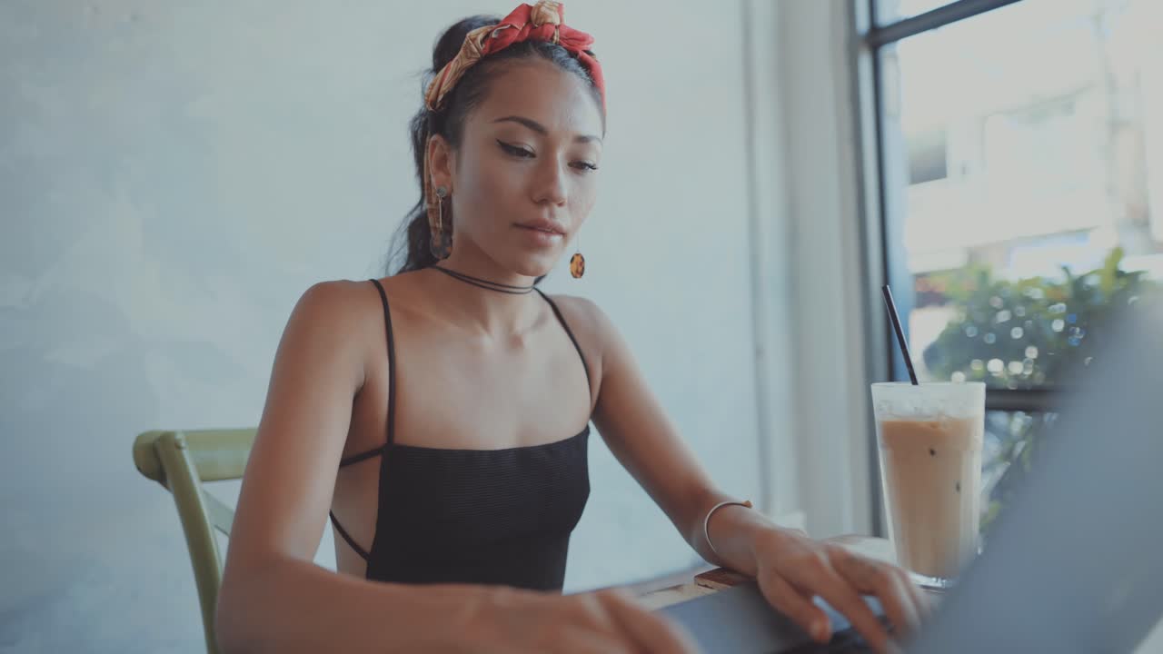 Woman working on laptop in a cafe