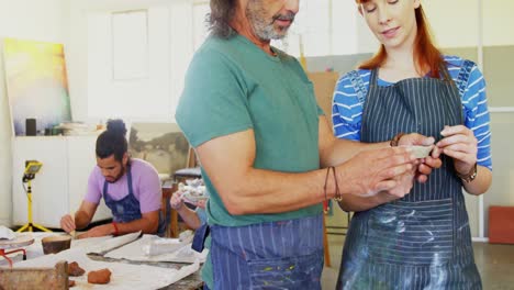 Drawing-teacher-assisting-woman-in-pottery-4k