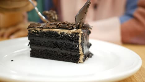 Women-eating-chocolate-cake-on-cafe-table-,