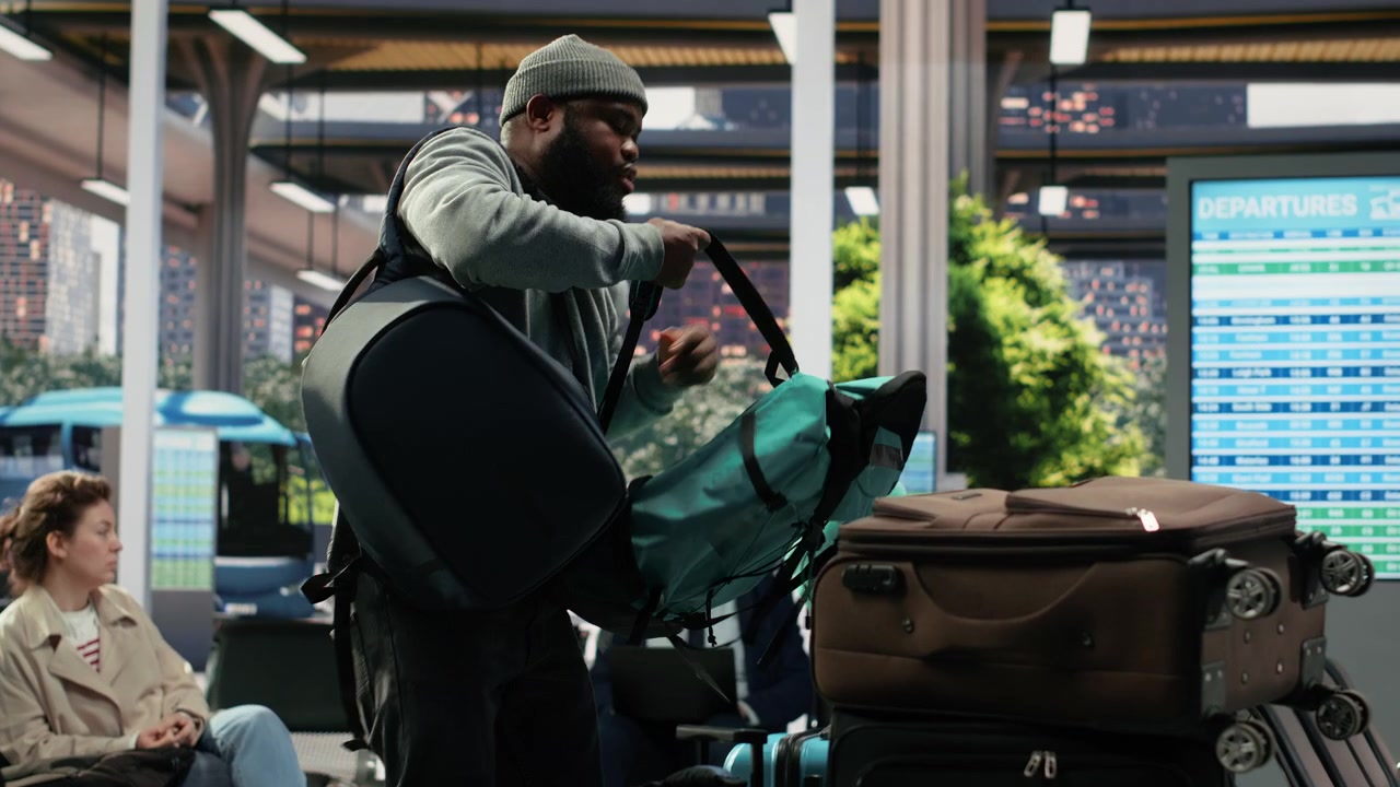 Homme fatigué rangeant des bagages volumineux dans une gare routière