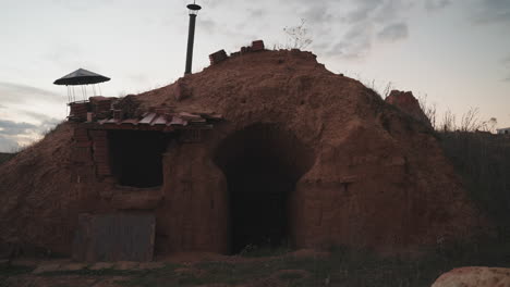 traditional underground furnace in rural spain amidst a vast landscape, at dusk