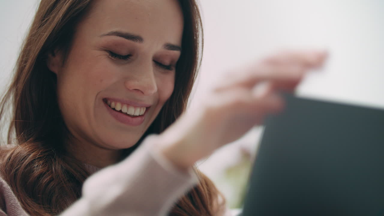 mujer morena agitando la mano a la pantalla del portátil