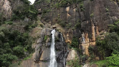 Cámara-Lenta-Entrando-En-Una-Toma-De-Cascada-Que-Fluye-Desde-La-Montaña-Rocosa-Media,-Sri-Lanka