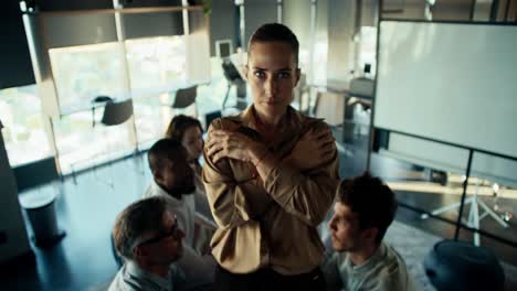 A-blond-woman-in-brown-business-clothes-falls-into-the-hands-of-her-colleagues.-Confidence-Therapy-in-the-Office