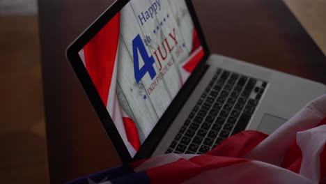 american flags with inscription happy independence day on laptop