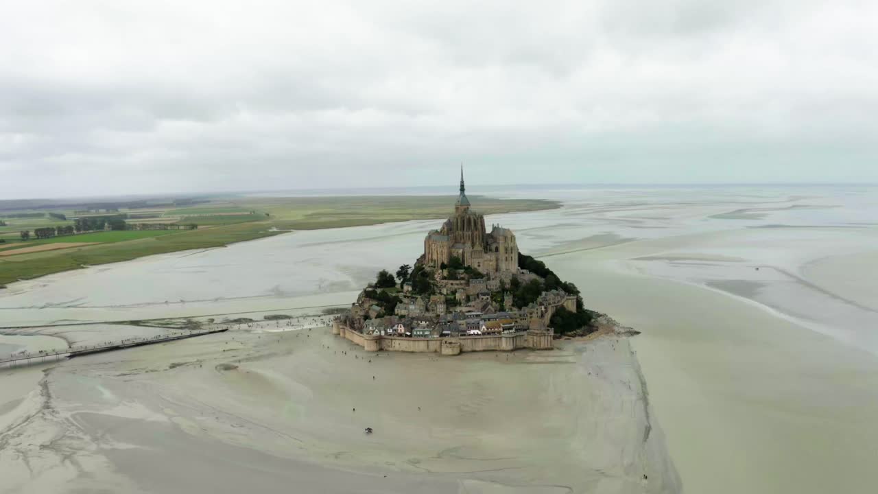 hay un castillo en el medio de la playa de mont saint michel donde hay muchos edificios castillo en francia