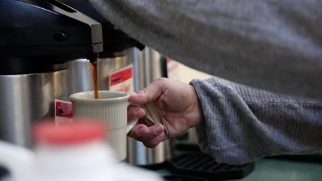 coffee poured in a cup from a cafeteria coffeepot.