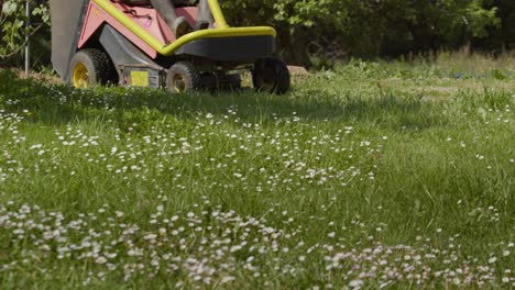 electric powered riding lawn mower over spring grass field