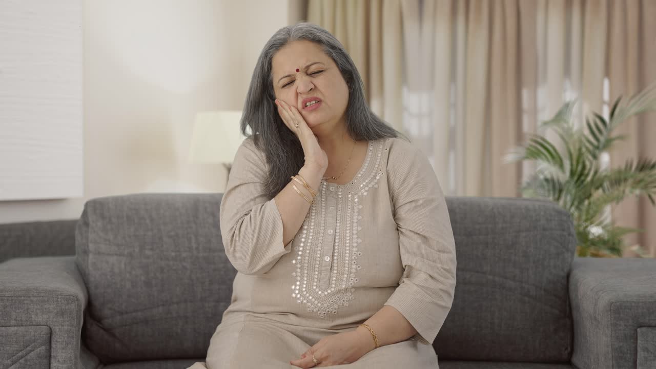 Sick Indian old woman suffering from tooth pain