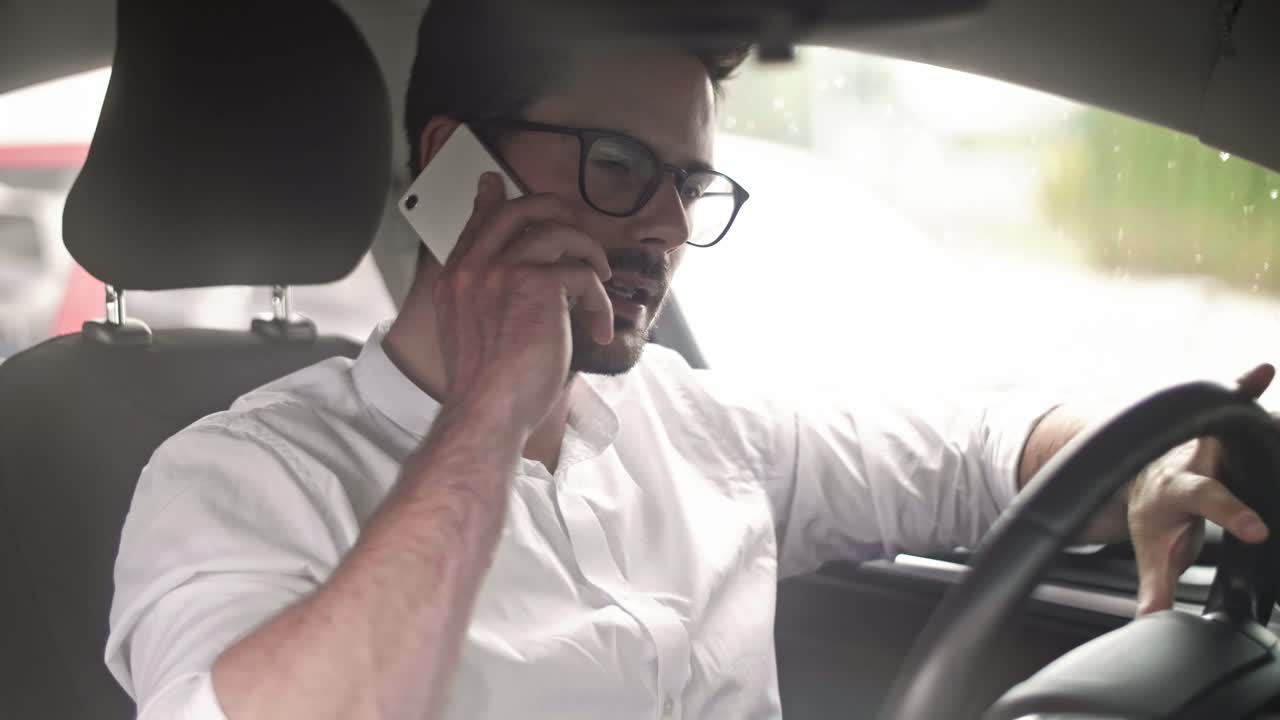 Geschäftsmann fährt Auto und telefoniert mit dem Handy