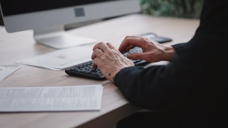 unrecognizable mature male employee working on laptop, hands typing on computer keyboard, tracking shot, free space