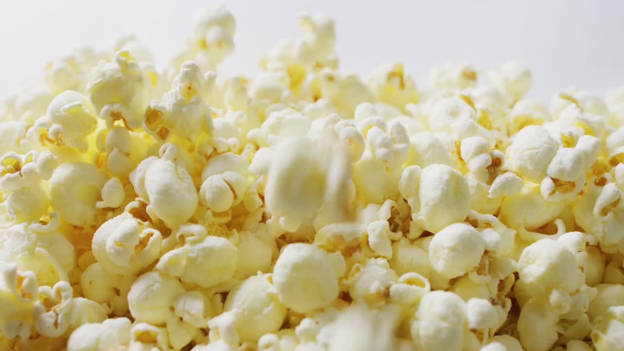 Video ravvicinato di popcorn che cadono su sfondo bianco