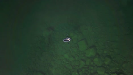 rising top down aerial shot of a lone boater in hatcher pass, alaska