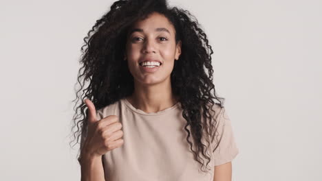 una mujer afroamericana sonriendo sobre un fondo blanco.