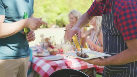 happy caucasian family having barbecue and eating in garden