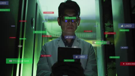 animación de iconos de las redes sociales contra un ingeniero masculino asiático que usa una tableta digital en la sala del servidor