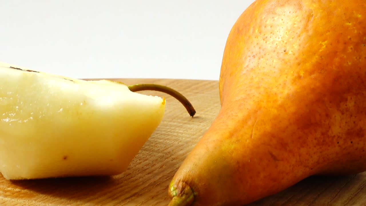 Pere su un tagliere di legno in cucina. Ripresa in movimento