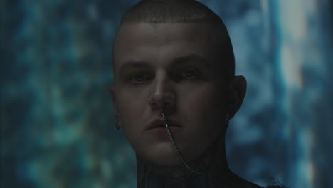 creative portrait of tattoed man with body jewelry