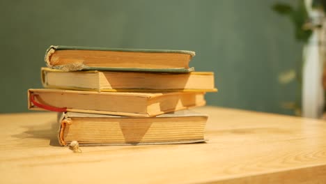 a stack of old books on a wooden table