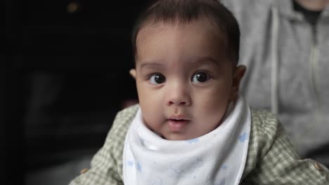 cute 4 month old baby wearing dribble bib looking at camera