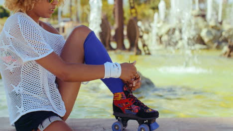 niña atándose los cordones de los zapatos en sus patines